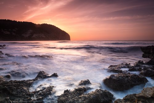 Rauhes Meer und glühender Himmel zum Sonnenaufgang in Canyamel